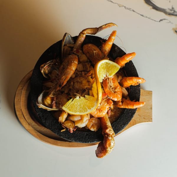 Las Islas VIP seafood dish with shrimp, crab, and clams, garnished with orange slices.